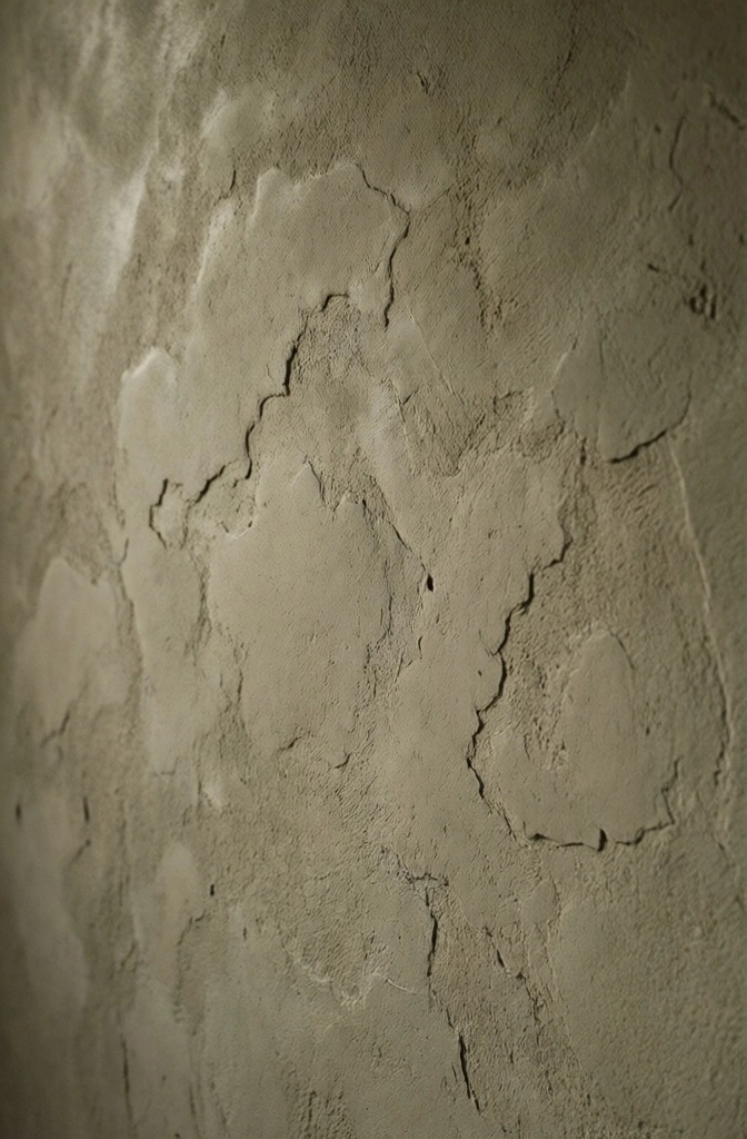 Close-up detail of the smooth, organic texture of beige micro-cement in a Japandi bathroom.